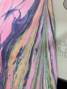 Close-up of water marbled textile showing blended pigment technique on twill fabric